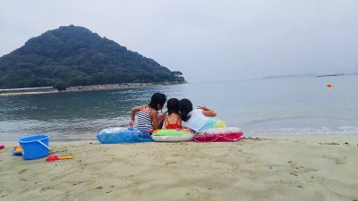 海岸で遊ぶ3人の少女たちの写真です。
